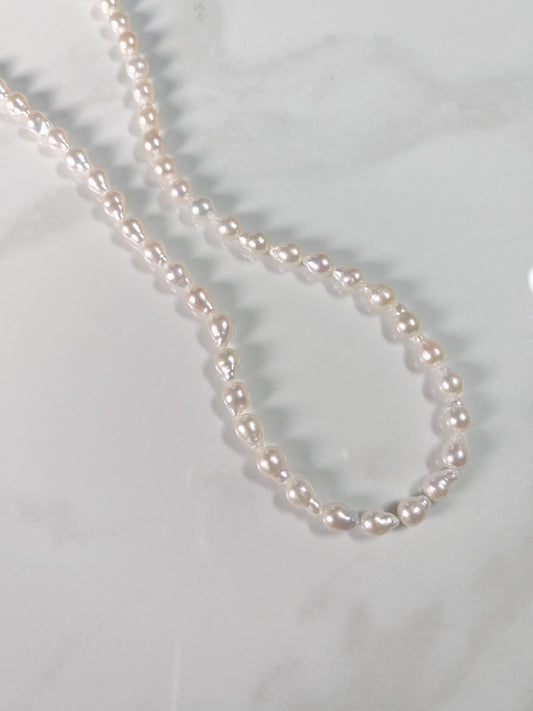 Pearl necklace on a light gray background