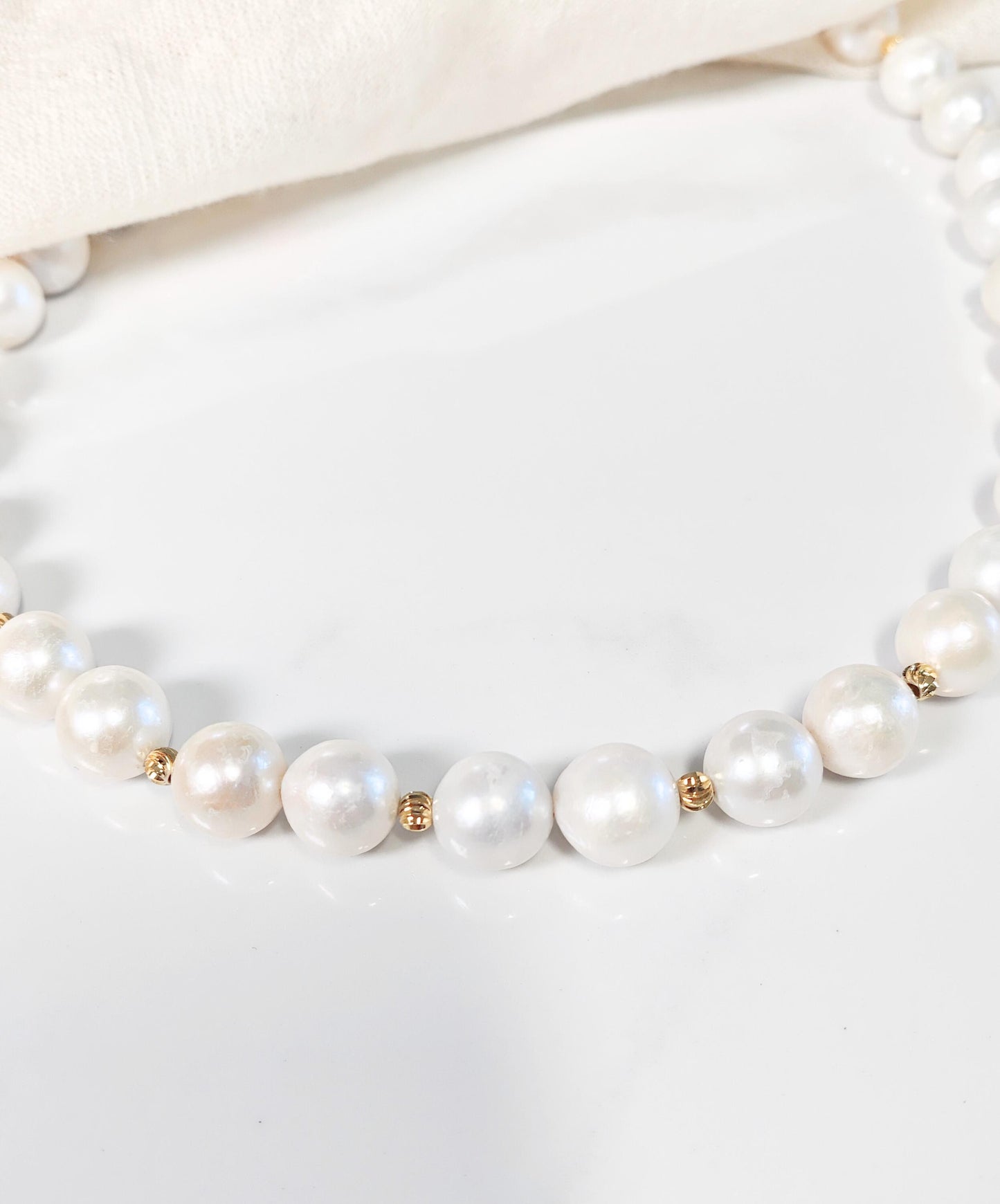 Pearl necklace with gold accents on a white background