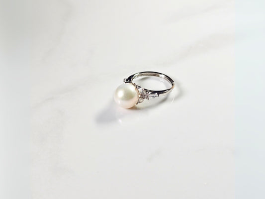 Pearl ring with silver band on a white background