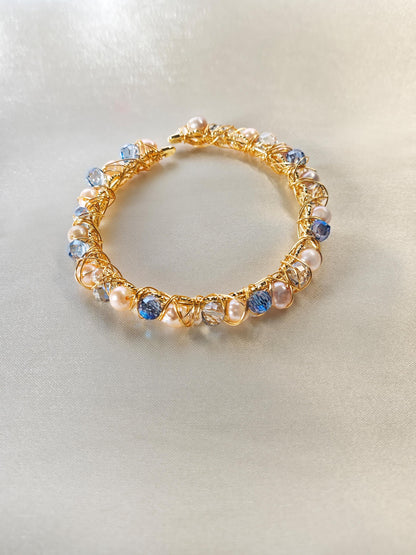 Gold bracelet with multicolored beads on a light gray background