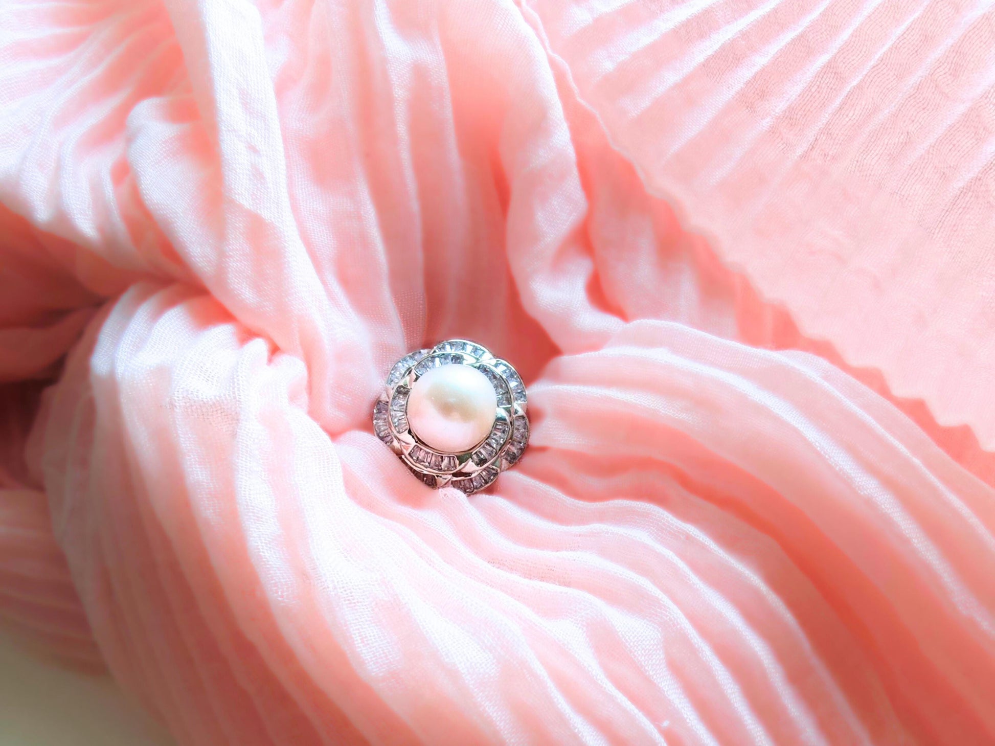 Close-up of a pink fabric flower with a pearl center