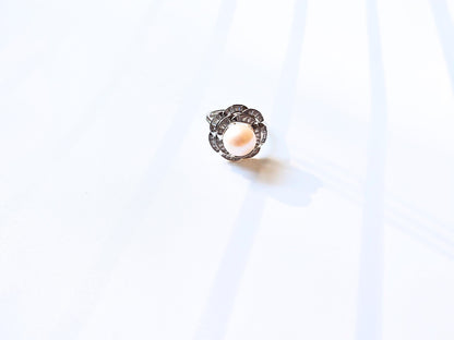 Silver ring with a central gemstone on a white background