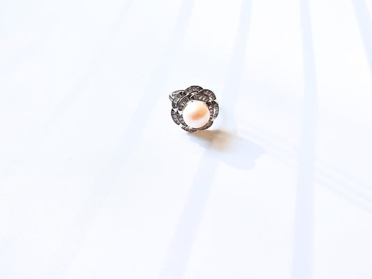 Silver ring with a central gemstone on a white background
