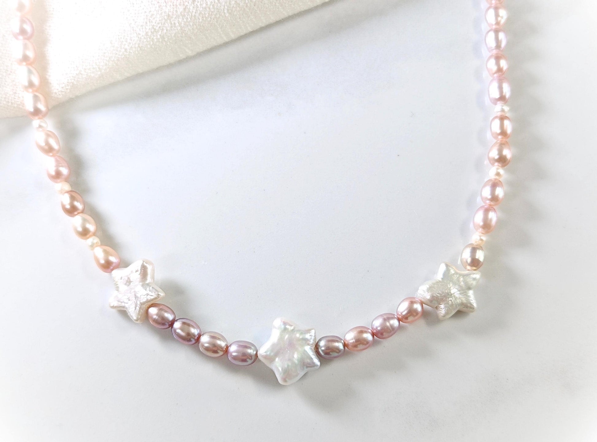 Pearl necklace with star-shaped beads on a white background
