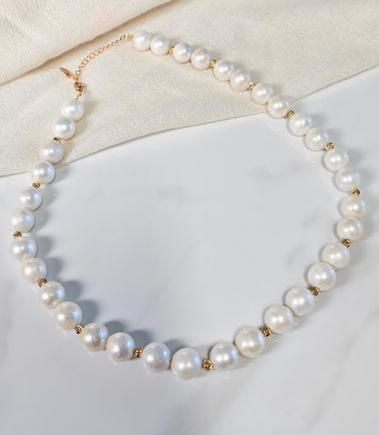 Pearl necklace with gold accents on a light background
