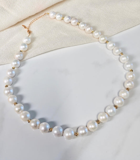 Pearl necklace with gold accents on a light background