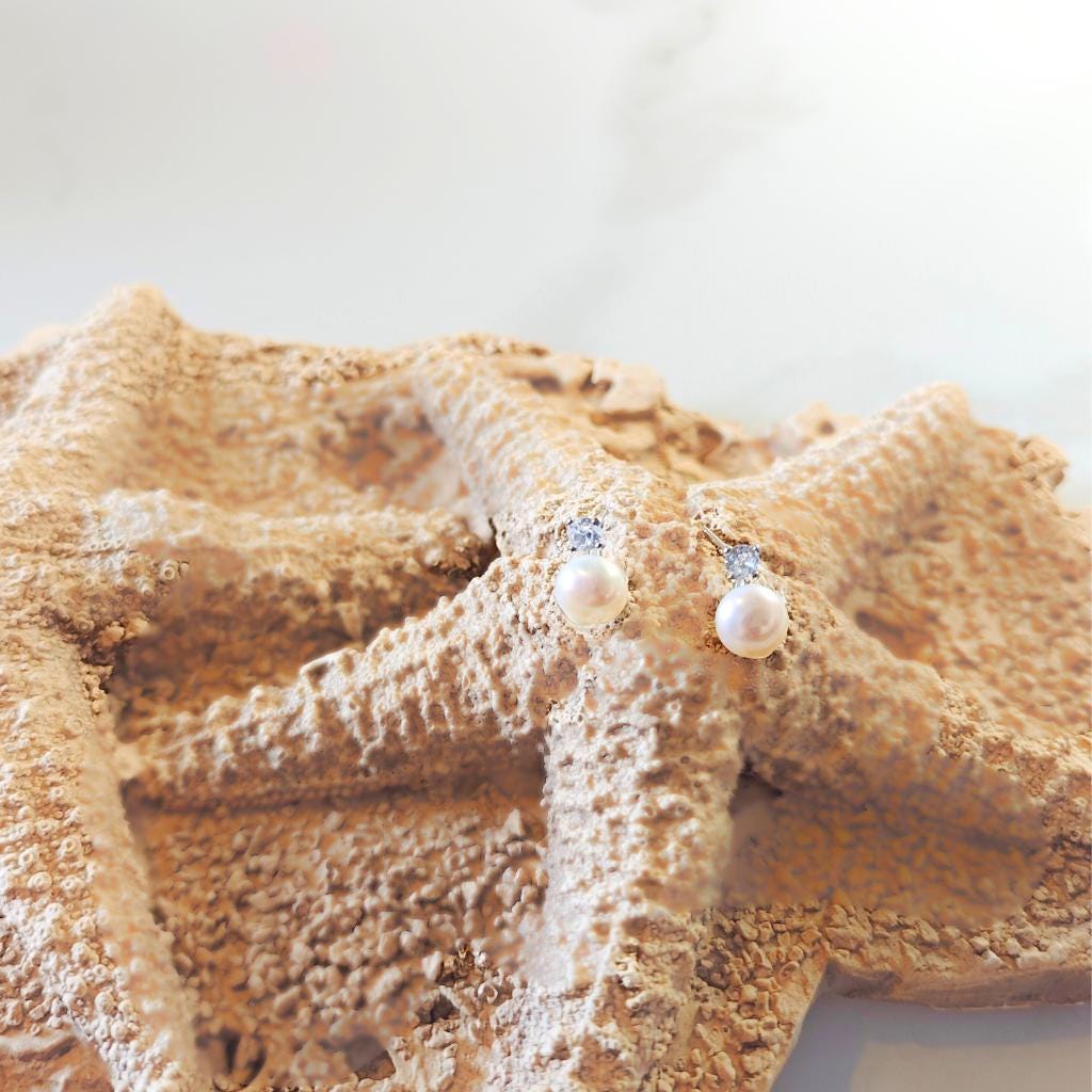 Starfish with pearl earrings on a white background