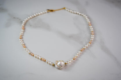 Pearl necklace with gold clasp on a marble surface