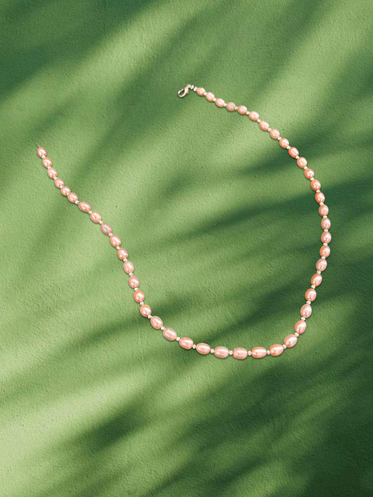Pearl necklace on a green leafy background