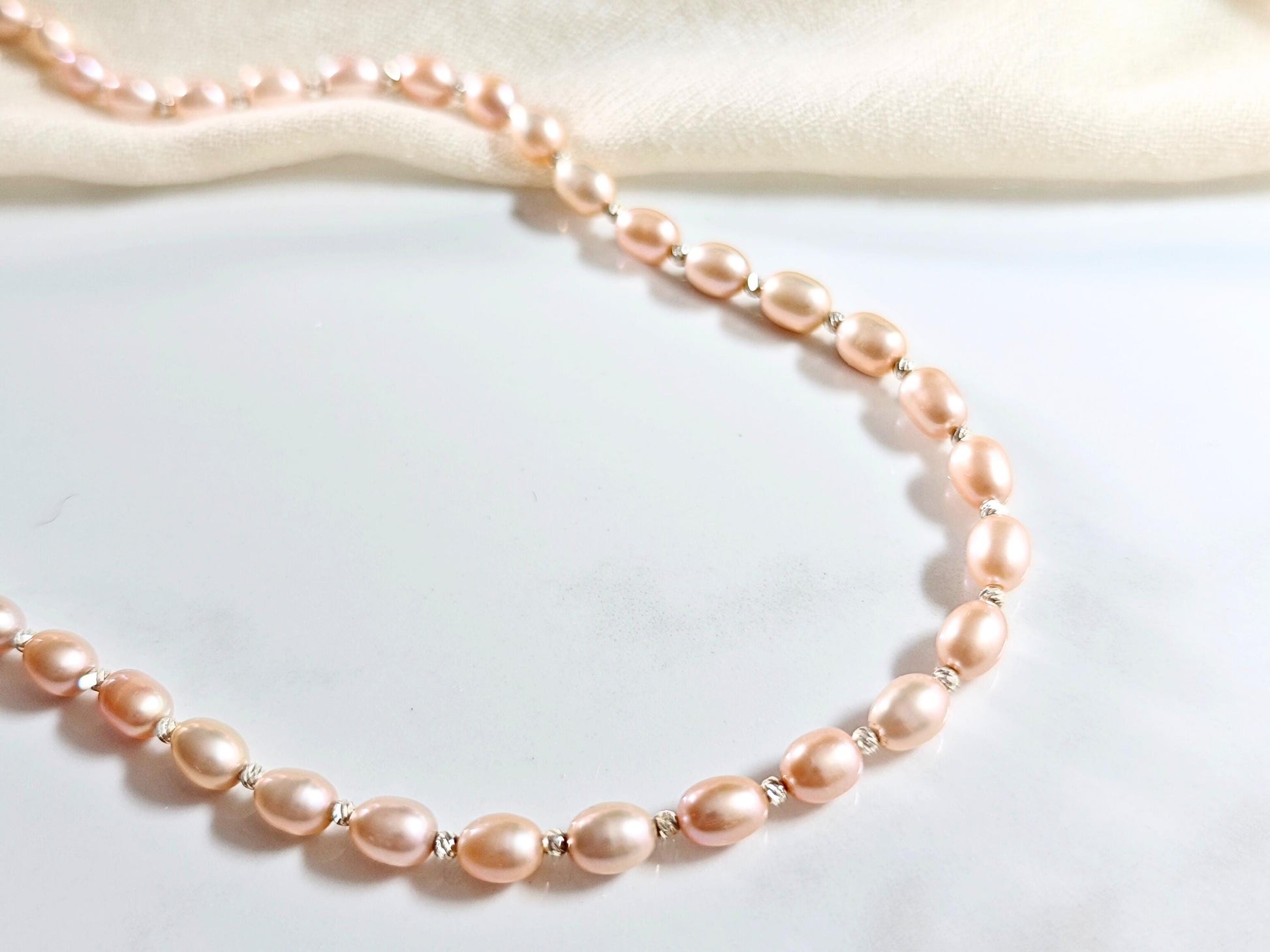 Pink pearl necklace on a light background