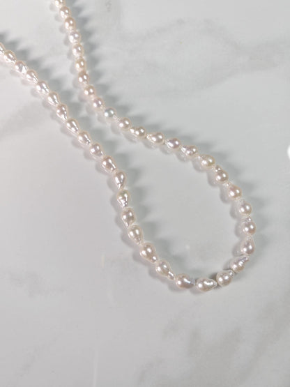 Pearl necklace on a light gray background