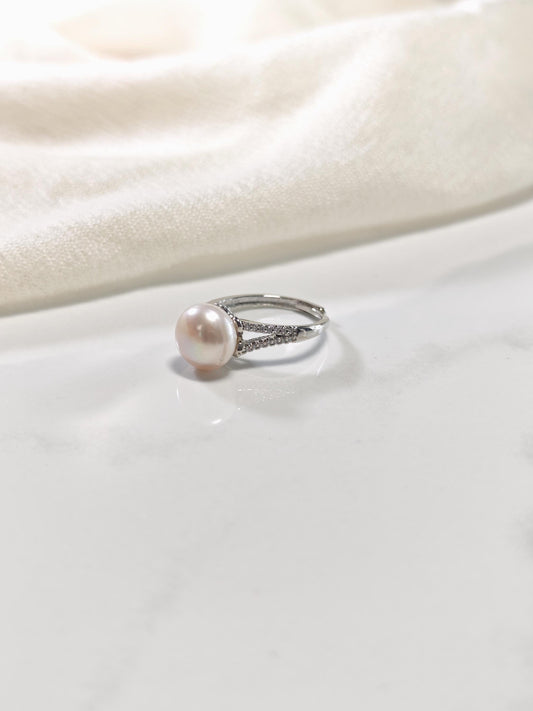 Pearl ring on a white fabric background