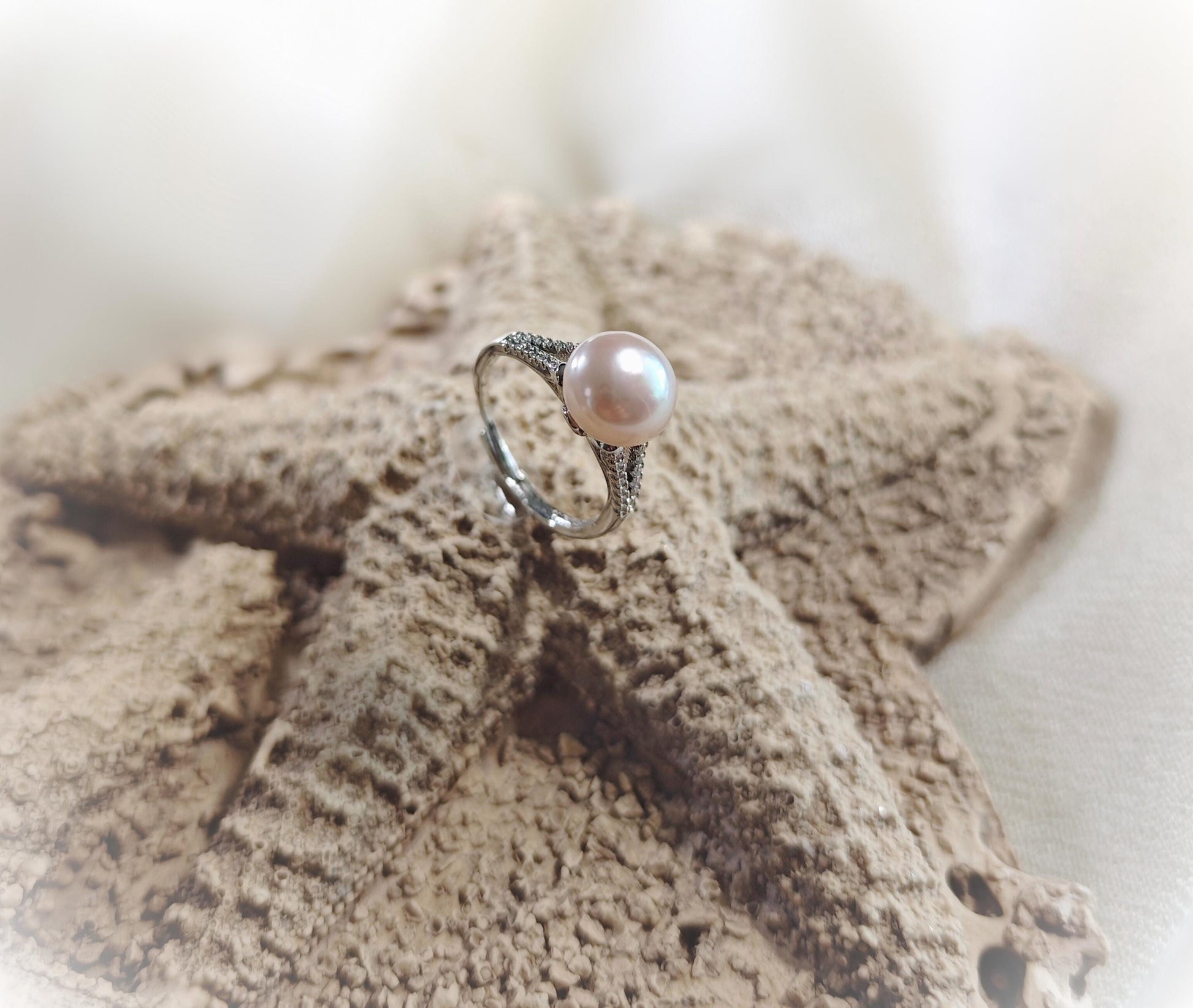 Pearl ring on a textured surface with a blurred background
