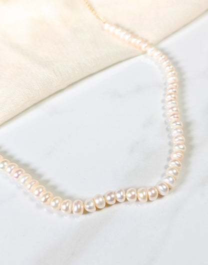 Pearl necklace on a light fabric background