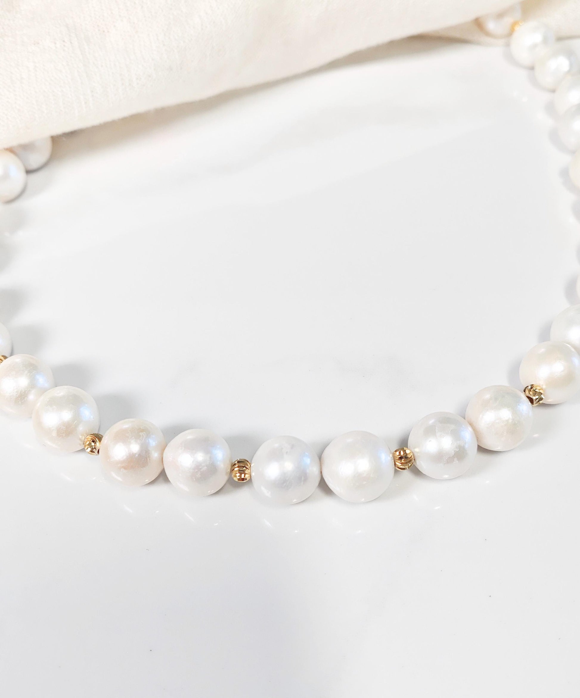 Pearl necklace with gold accents on a white background