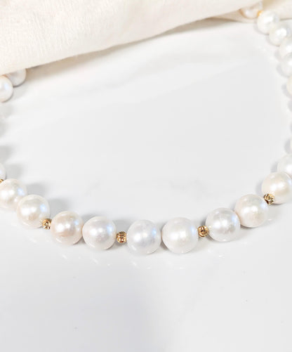 Pearl necklace with gold accents on a white background