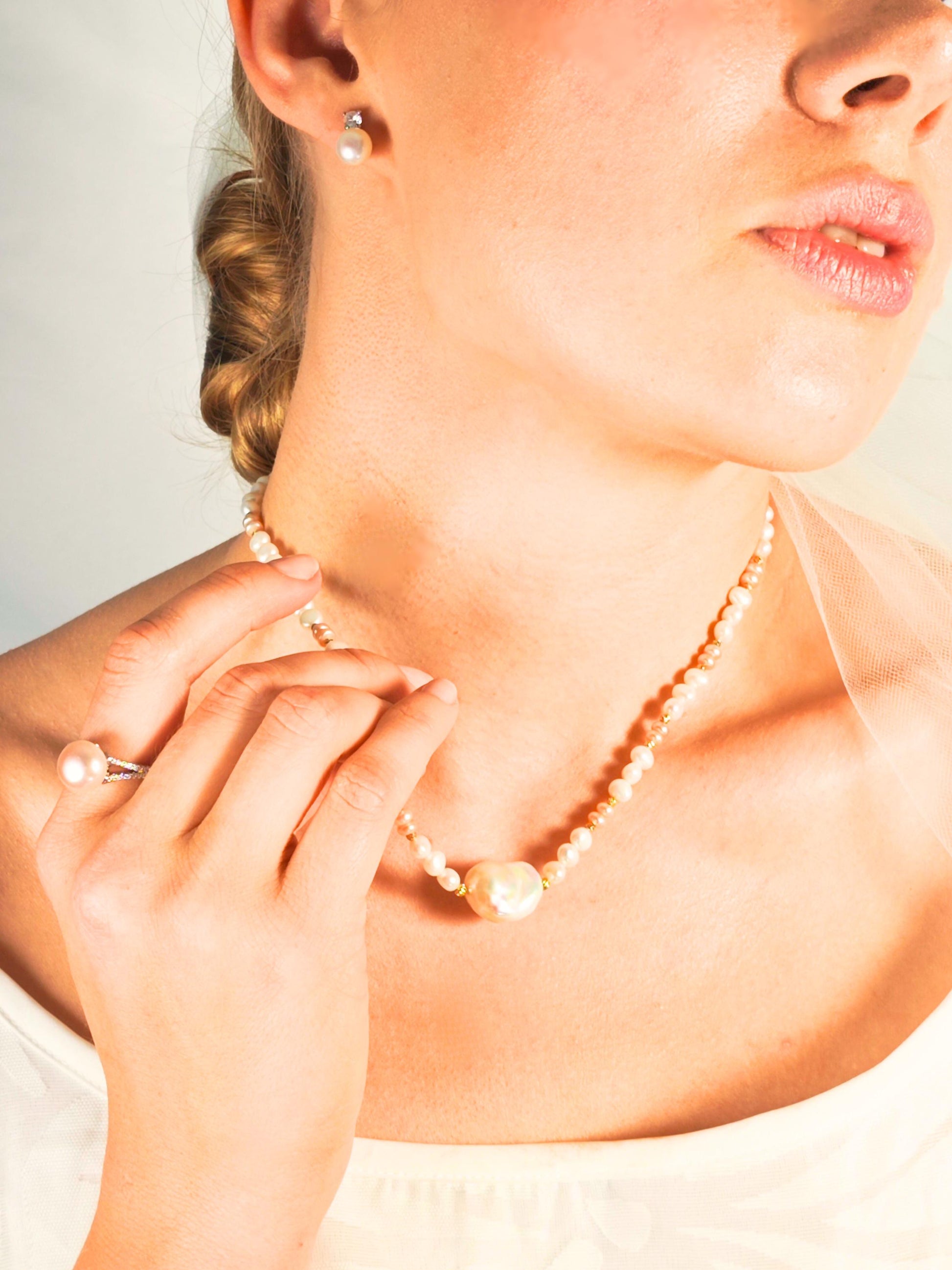 Close-up of a woman wearing a pearl necklace and earrings.