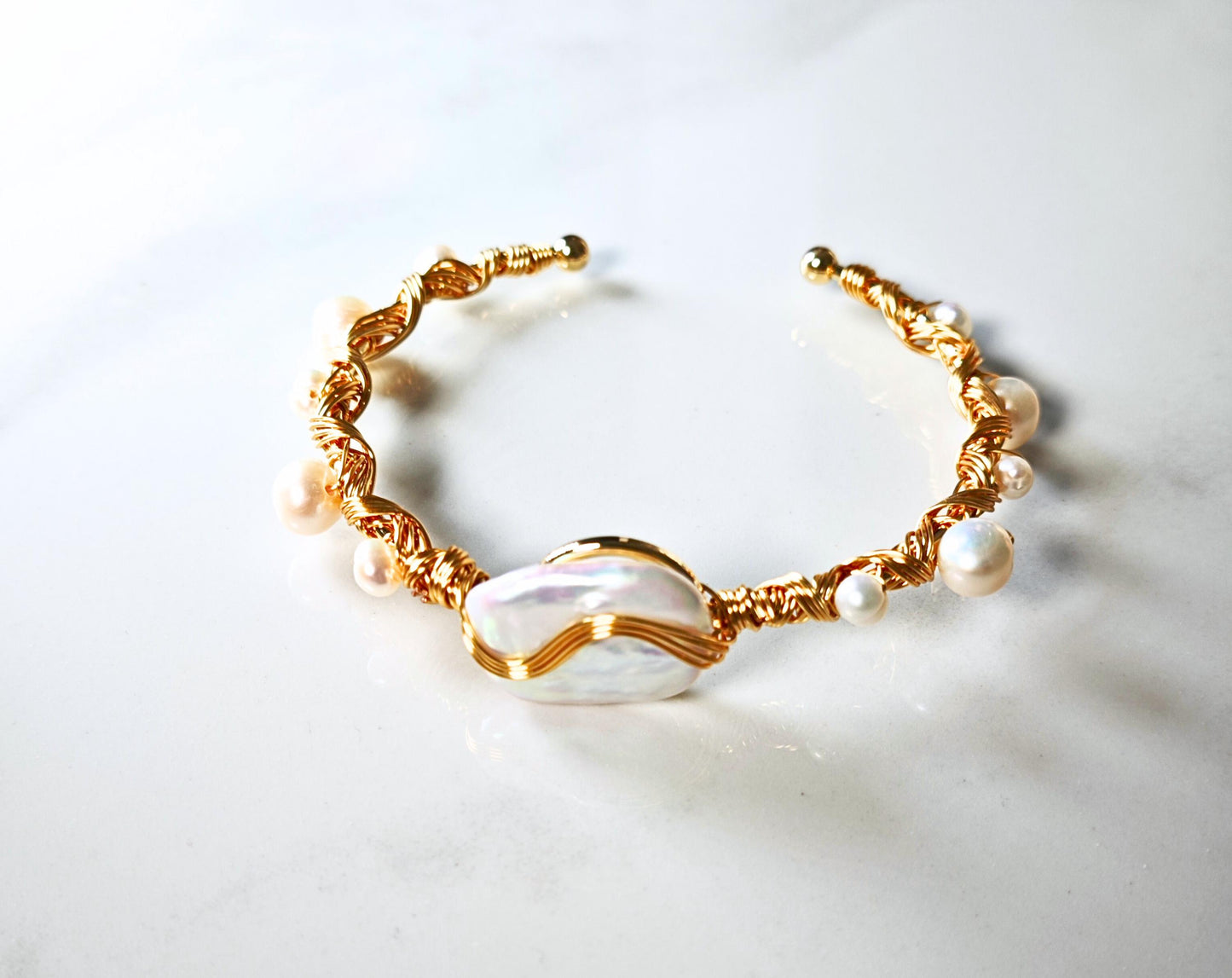Gold and pearl bracelet on a light background