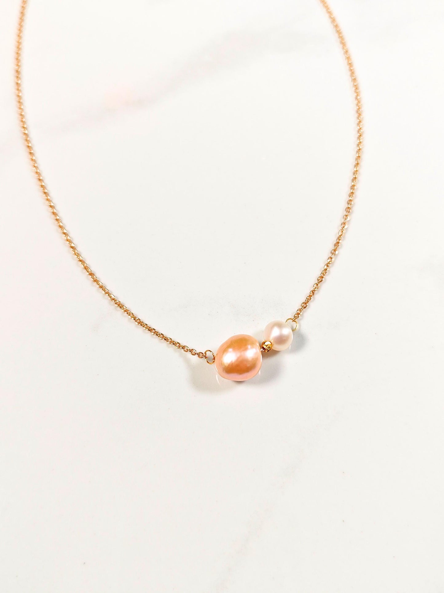 Necklace with pink and white pearls on a light background