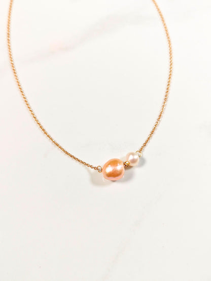 Necklace with pink and white pearls on a light background