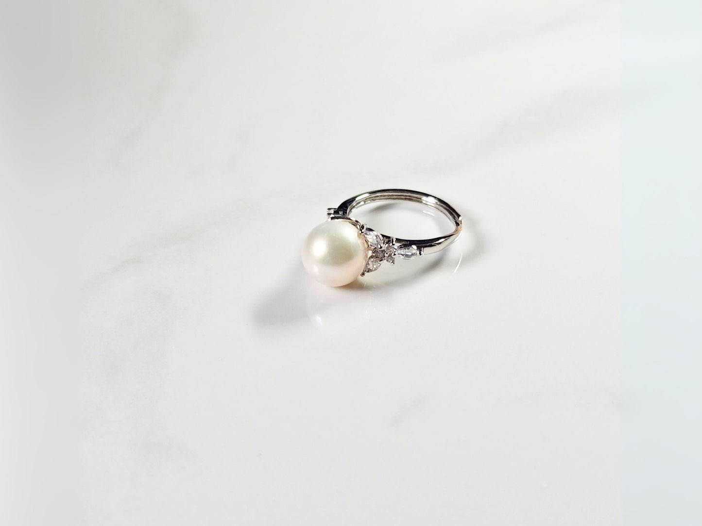 Pearl ring with silver band on a white background