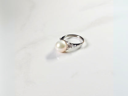 Pearl ring with silver band on a white background