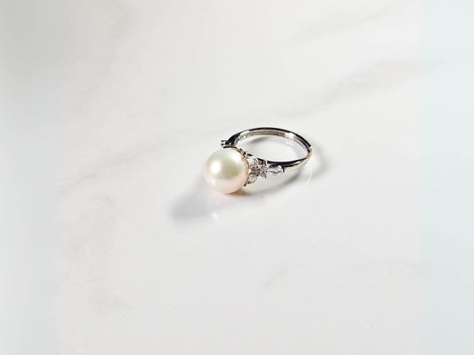 Pearl ring with silver band on a white background