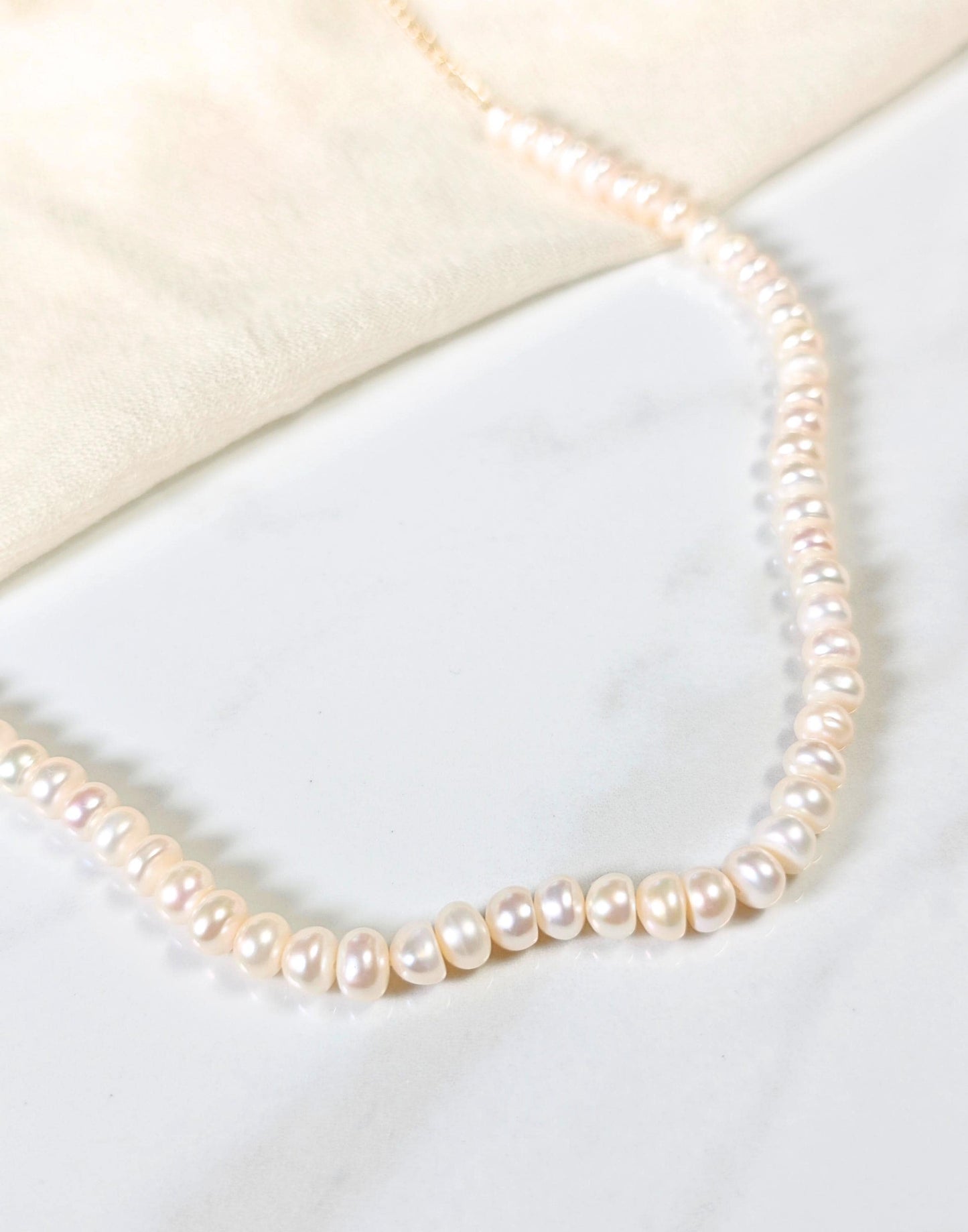 Pearl necklace on a white surface