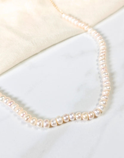 Pearl necklace on a white surface
