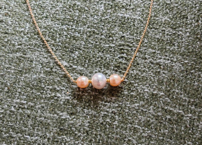 Pearl necklace on a textured green surface