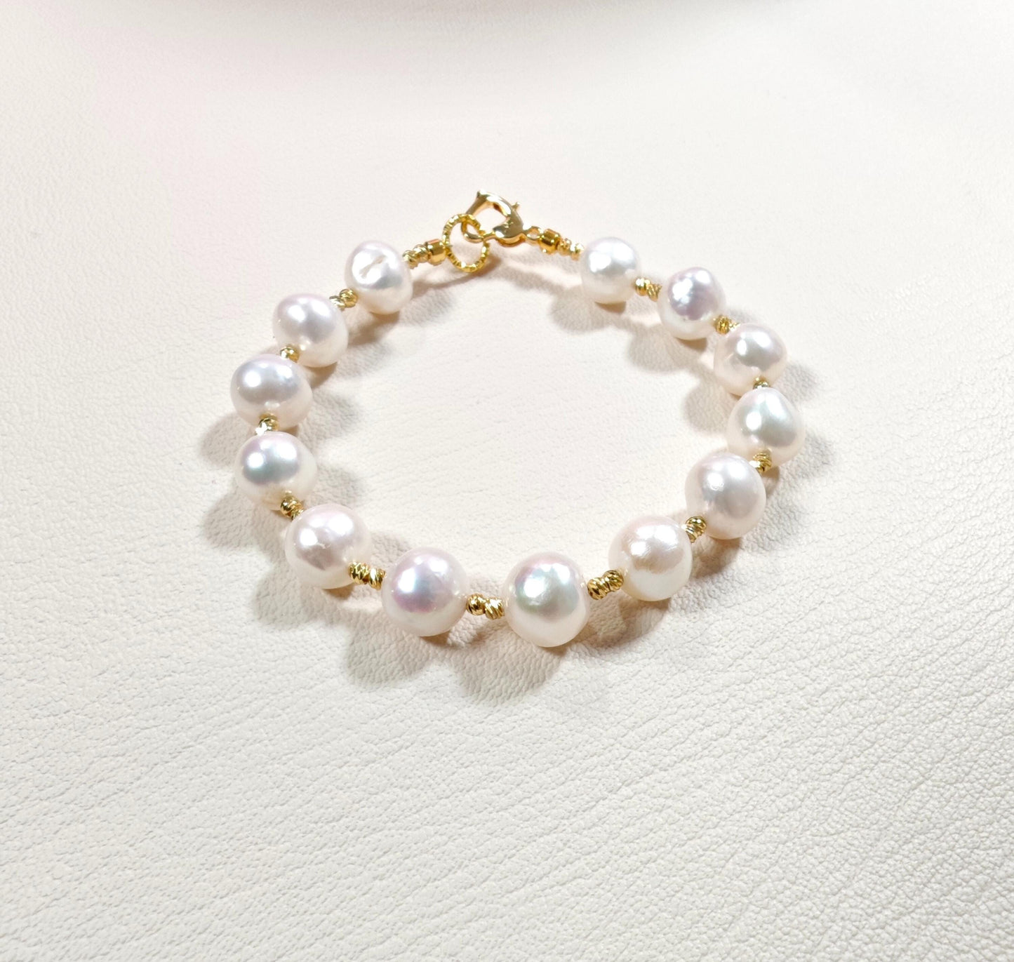 Pearl bracelet with gold accents on a light background