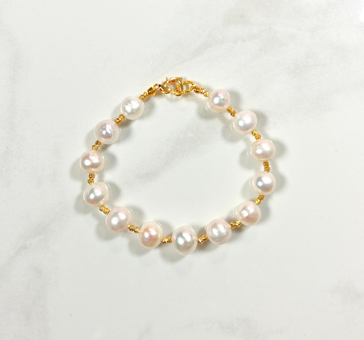 Pearl bracelet with gold chain on a white background