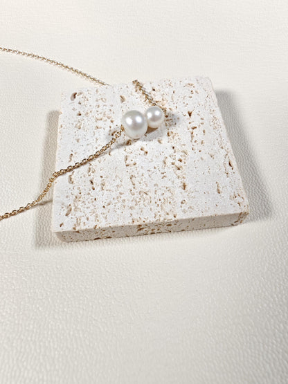 Pearl necklace on a textured stone surface with a light background