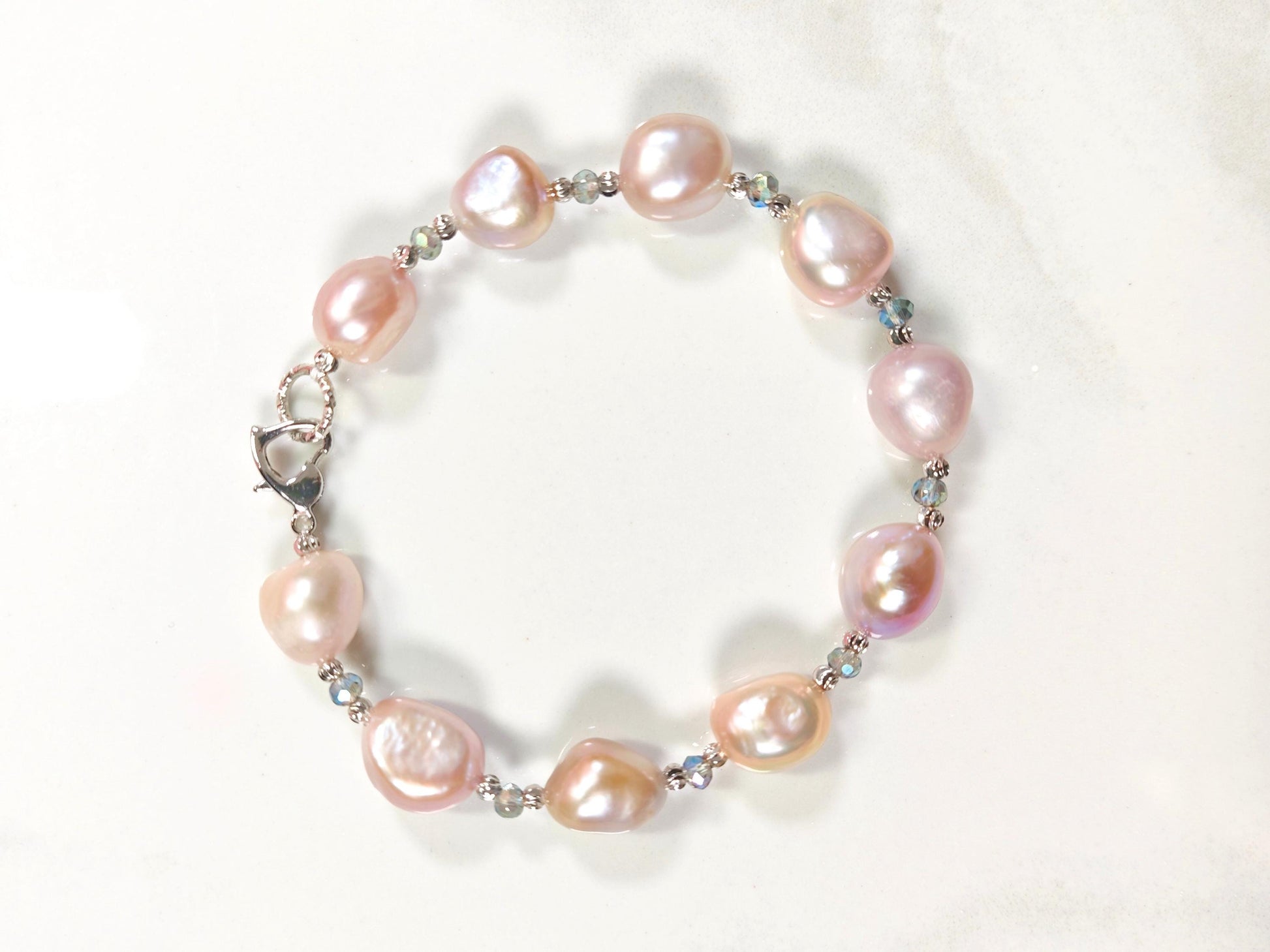 Pearl bracelet with pink and silver beads on a white background