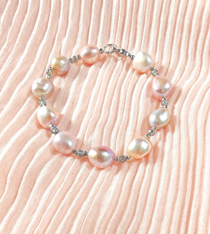 Pearl bracelet with silver accents on a pink textured background