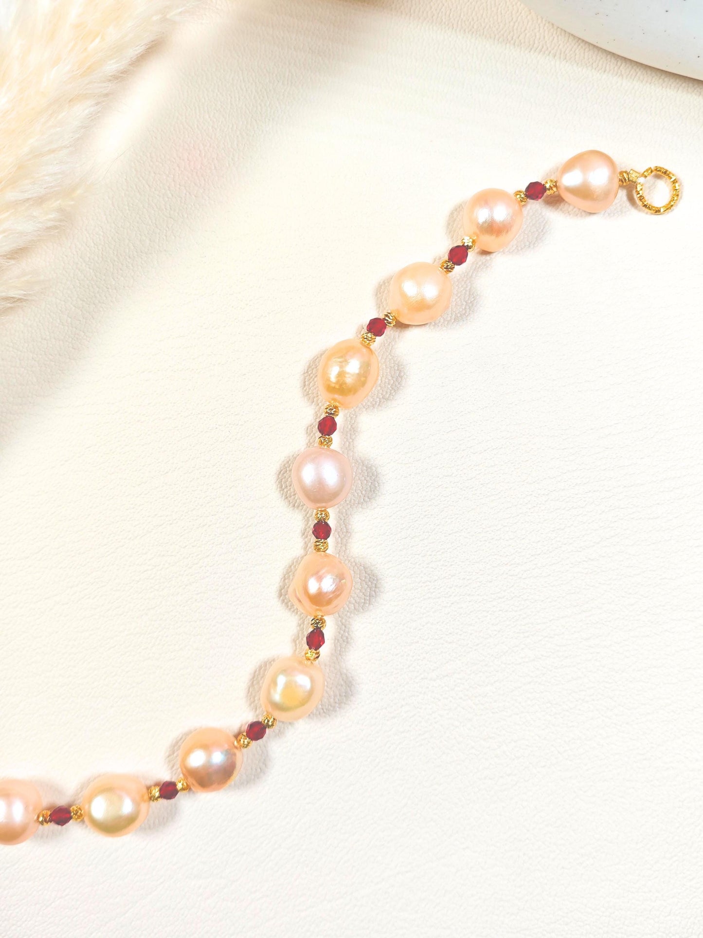 Pearl bracelet with gold clasp on a white background