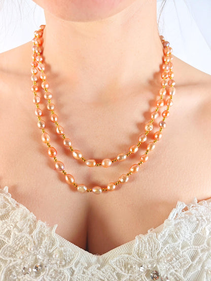 Pearl necklace worn by a person in a white lace garment