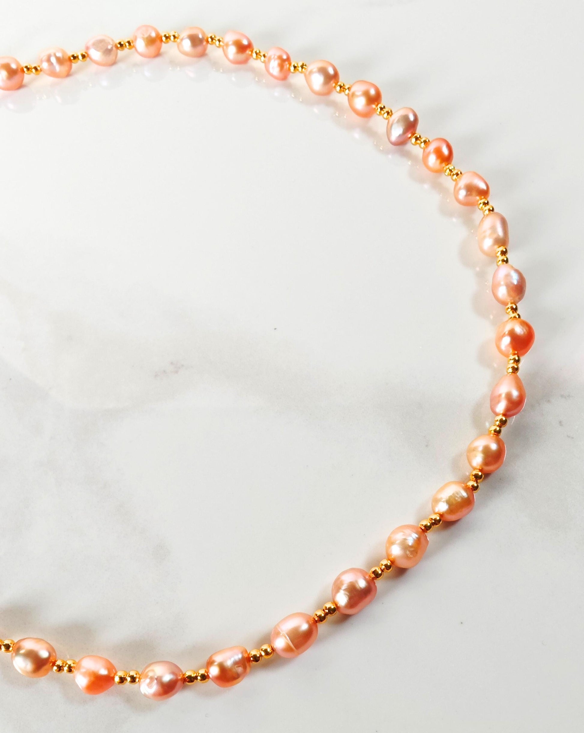 Pearl necklace with gold accents on a light background