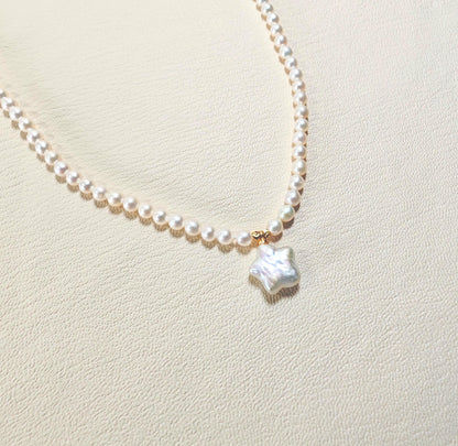 Pearl necklace with a star-shaped pendant on a light beige background