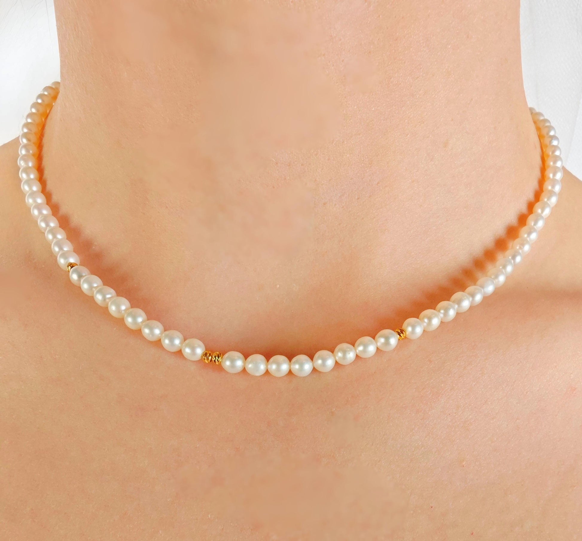 Pearl necklace being worn on a person's neck