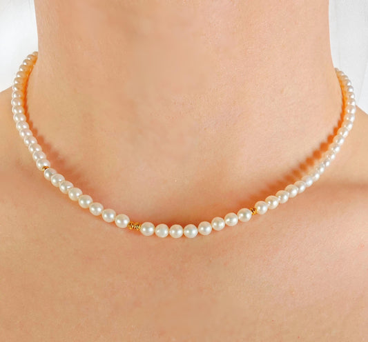 Pearl necklace being worn on a person's neck