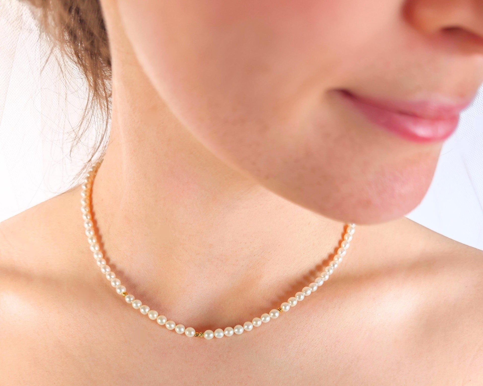 Pearl necklace worn by a person with a blurred background
