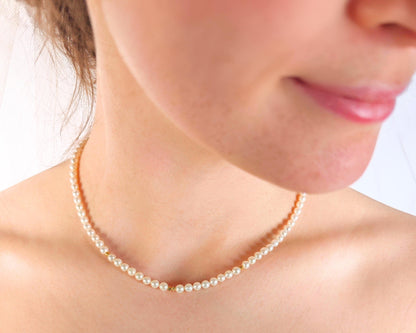 Pearl necklace worn by a person with a blurred background