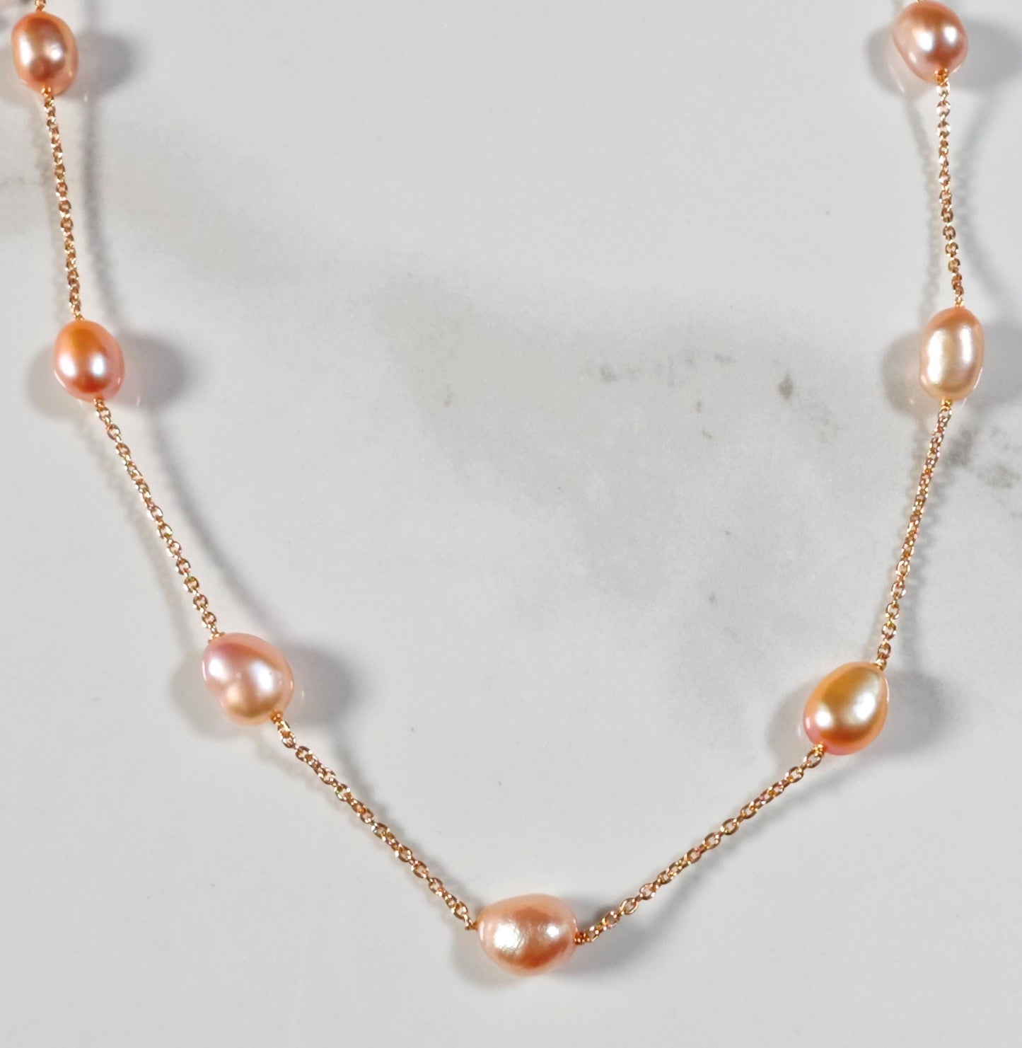 Necklace with pink pearls on a light gray background