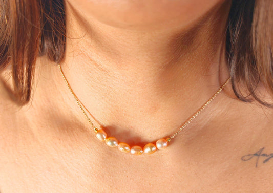 Pearl necklace on a person's neck with a blurred background