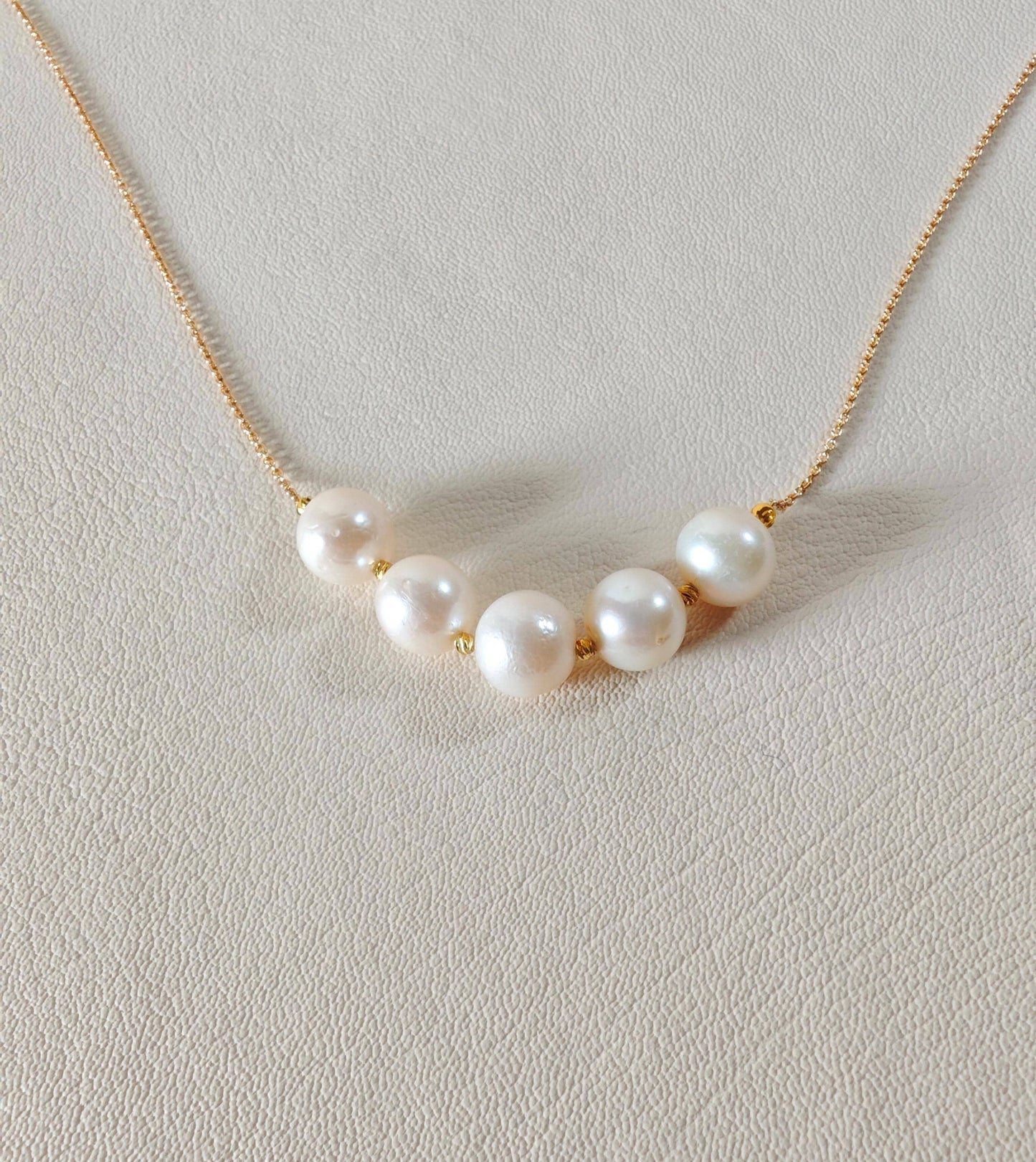 Pearl necklace on a light gray background