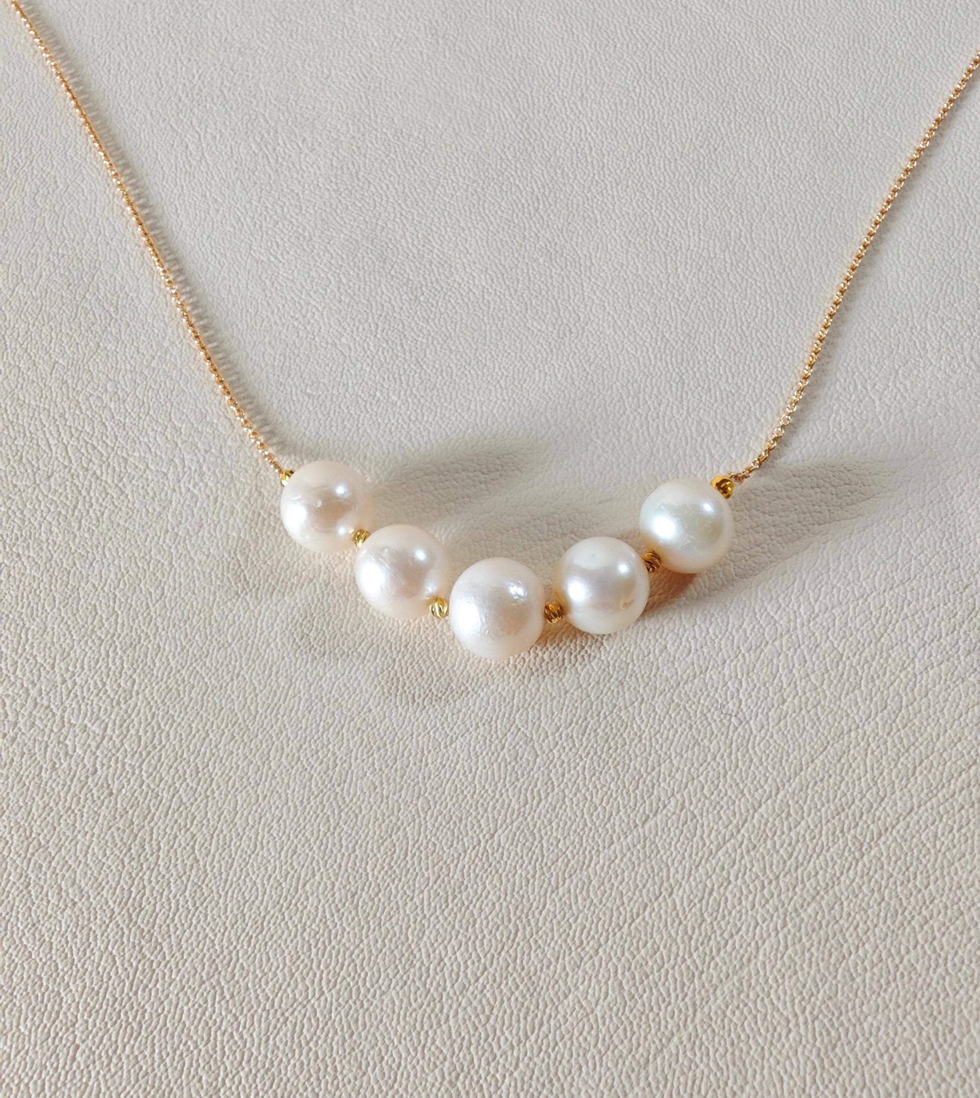 Pearl necklace on a light gray background