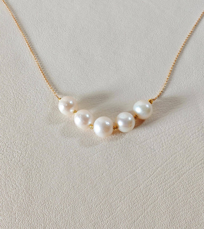 Pearl necklace on a light gray background