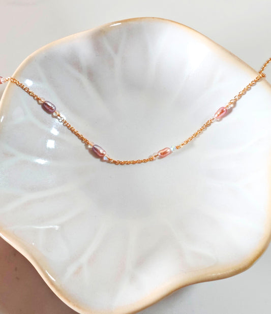 Necklace with pink beads on a white dish