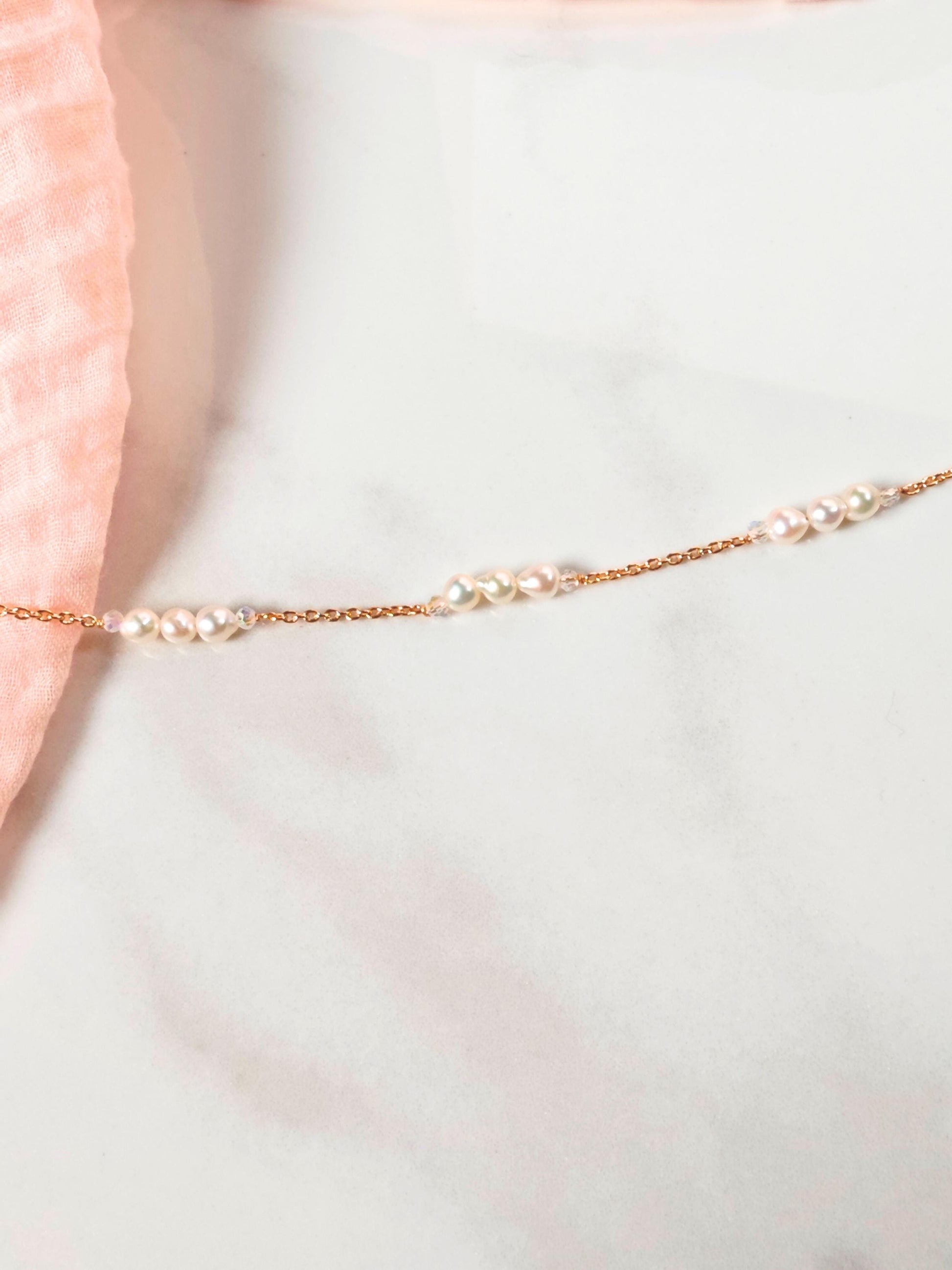 Gold bracelet with pearls on a light background